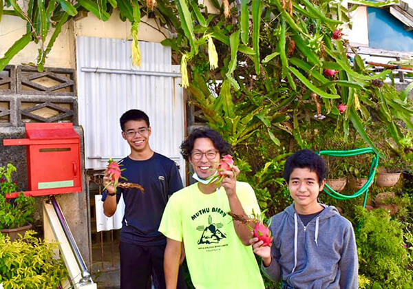 地域の庭木に水やりをし、ついにはドラゴンフルーツを収穫。なんでもない、誰でもできることを実施する菅原さんと子どもたち。